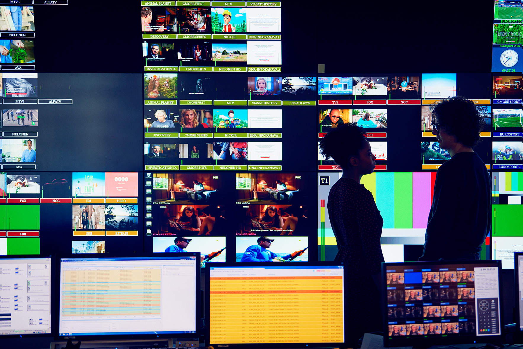 Kaksi henkilöä valvomassa televisiolähetyksiä